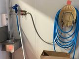un tuyau bleu fixé au mur à côté d'un évier