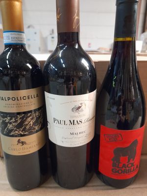 trois bouteilles de vin posées sur une caisse en bois