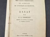 un livre ouvert posé sur une table à côté d'une table noire