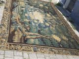 un tapis posé sur le trottoir, sur lequel se détache l'ombre d'une personne