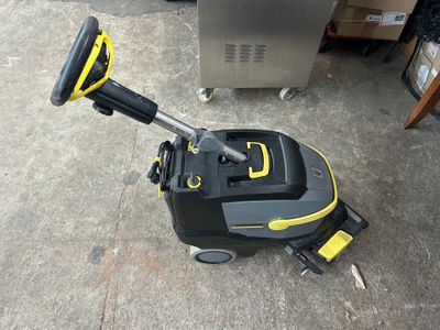 un gros plan d'un aspirateur jaune et noir posé par terre