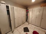 several white lockers in a room with a red chair in front of them