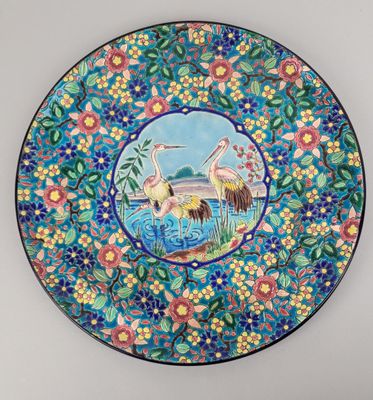 a close up of a decorative plate with birds and flowers on it