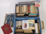 de nombreux livres dans une boîte bleue posée sur une table blanche
