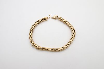 a gold bracelet with a braid design on a white background