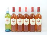 quatre bouteilles de vin posées les unes à côté des autres sur une surface blanche