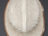 a close up of a hat on a table with a black background