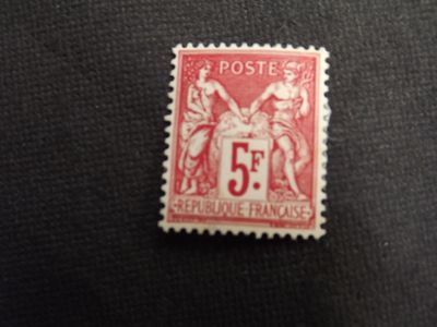a close up of a red and white stamp on a black surface