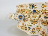a large white vase with blue and yellow flowers on it