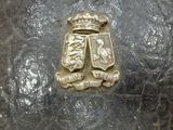 a metal object with a gold crown on top of it