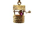 an image of a gold charm with a basket and a heart