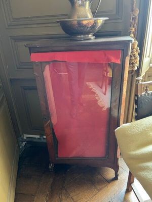 une poubelle rouge posée sur un plancher en bois