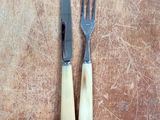 two forks and a knife on a cutting board