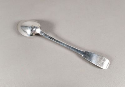 une cuillère en argent avec un manche de cuillère sur une table