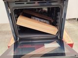 an open oven with a wooden box inside of it