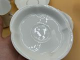 a person holding a bowl and a plate on a table