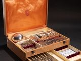 a wooden box with silverware in it on a black surface