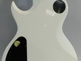 a close up of a white electric guitar with a black body