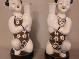 paire de figurines en céramique représentant un homme et une femme tenant un vase
