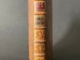 an old book with a wooden cover sitting on top of a table
