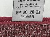 the label of a red sweater is attached to the back of a red sweater