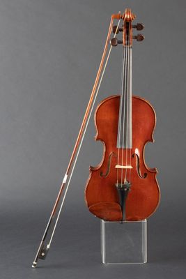an old violin sitting on top of a clear stand next to a bow