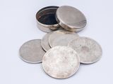 a pile of silver coins sitting on a white surface