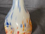 a white vase with a blue and yellow design on it