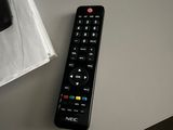 a remote control sitting on a table next to a book