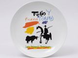 une assiette blanche sur laquelle sont représentés un cow-boy et une vache