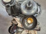 une théière en argent, accompagnée d'une tasse et de cuillères, posée sur une table