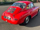 une voiture rouge garée dans un parking