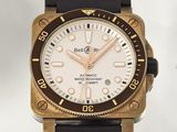 a gold and black watch with a white dial