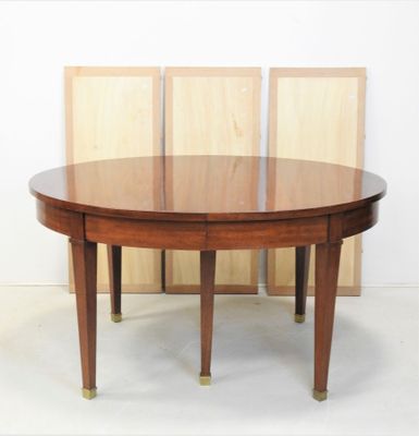 une photo d'une table à manger ronde avec quatre chaises