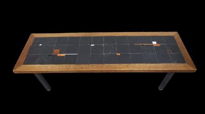 une petite table avec un plateau en carrelage noir sur fond noir