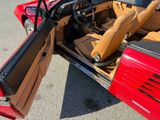 a red sports car with its door open and a steering wheel in it