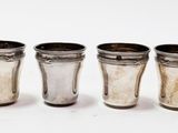 six shot glasses are lined up in a row on a white surface