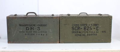 pair of vintage military ammo cans sitting on top of a white table