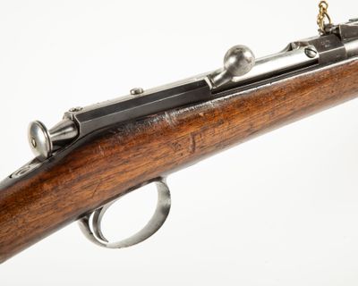 un gros plan d'un fusil sur fond blanc, avec une chaîne