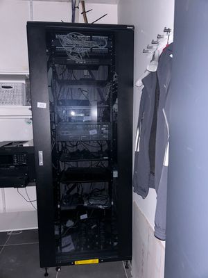 une photo d'une armoire de serveurs dans une petite pièce