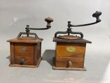 pair of antique wooden coffee grinders with brass handles and knobs