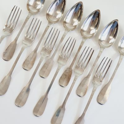 a lot of silver spoons and forks on the table