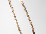 un collier à chaîne en or sur fond blanc