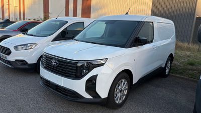 plusieurs fourgonnettes blanches garées sur un parking à côté d'un immeuble
