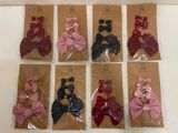 six pairs of small bows are in a package on a table