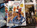 a lot of comic books on the table together