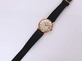 a close up of a watch on a white surface with a black strap