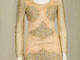 a mannequin dress with sequins and beads on a mannequin stand