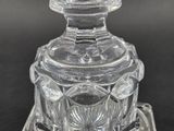 an antique cut glass vase on a stand on a black surface