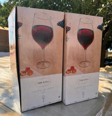 two boxes of wine sitting on top of a table next to each other